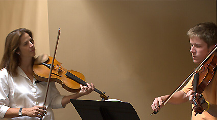 a woman and man playing viola