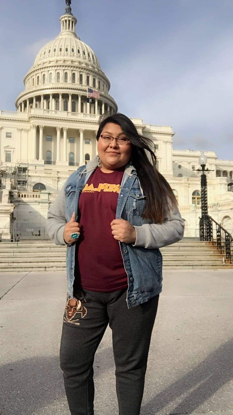 Erla Sagg, M.A. (Diné), the first graduate of the online BA in Native American Studies on the steps of the Capitol