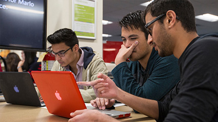 advisor and student working on computer