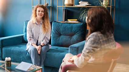 Two people sitting on a couch talking